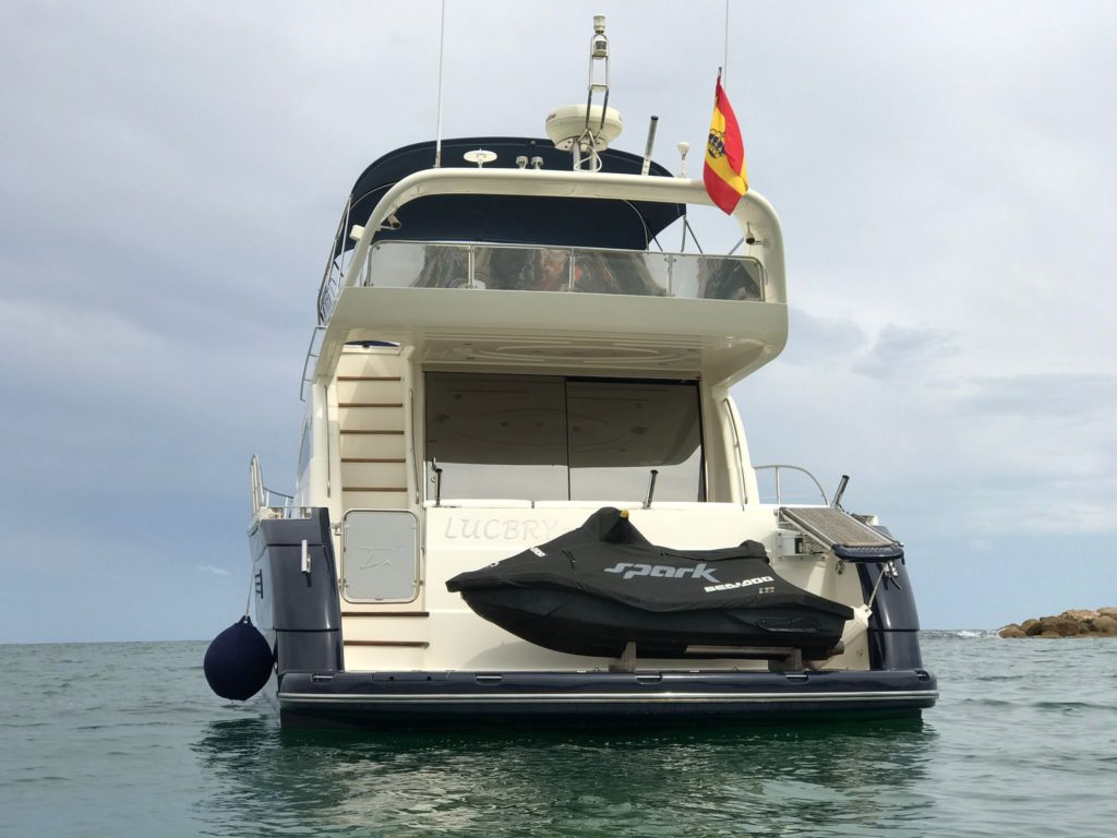 Location de bateau 
Roadman 56 au large, quitte le port, à l'eau, avec le Jet Ski à l'arrière.